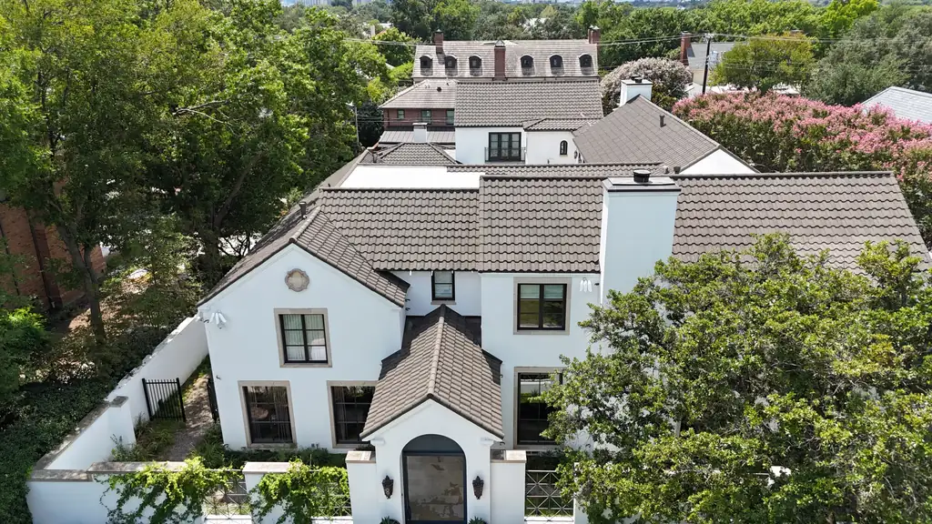 Drone view of a finished brown tile roof on a white stucco home, replaced by Dimensional Pro Construction