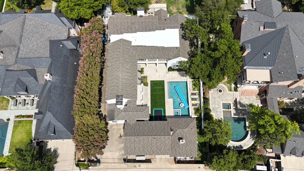 Overhead drone view of a finished tile roof around a backyard courtyard and pool