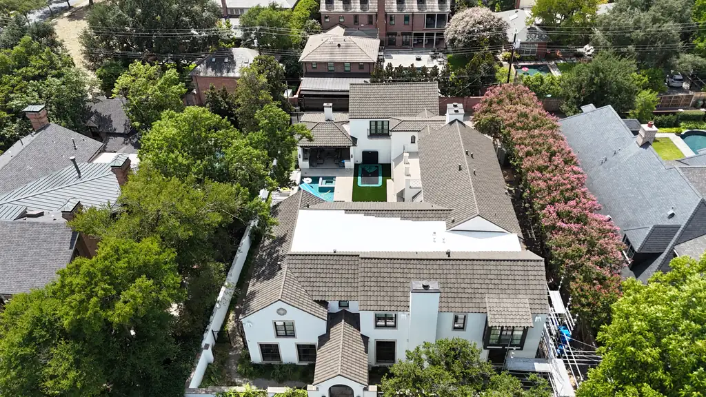 Finished tile roof and white flat-roof section on a two-story stucco home, seen from above