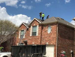 Workers on brick home roof