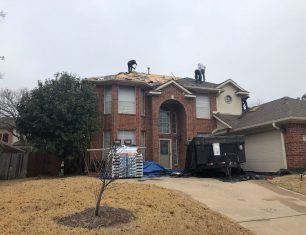 Workers fixing brick house roof