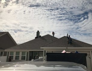 Workers on top of roof, cloudy day