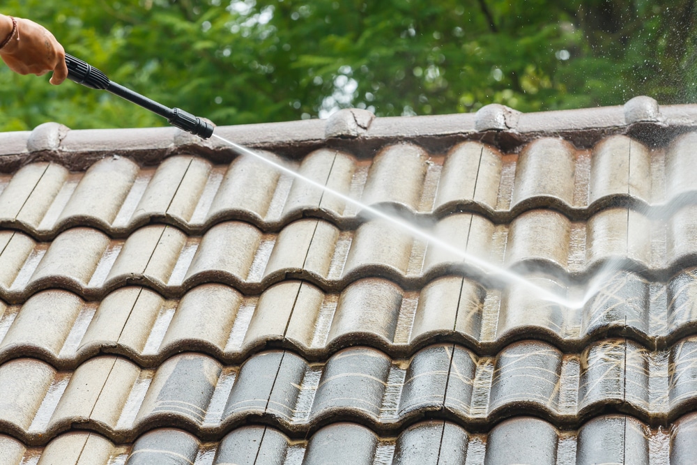Picture of worker cleaning roof with power washer